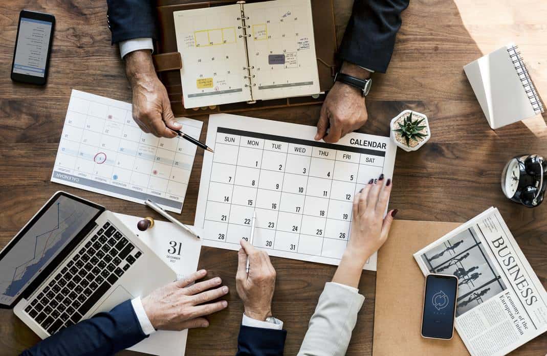 People scheduling meetings with pen and paper